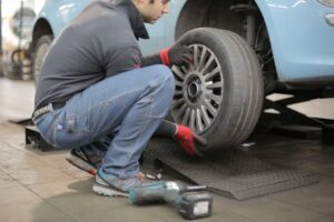 man replacing a car tyre